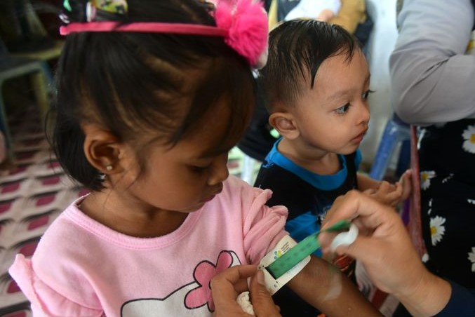 Petugas kesehatan mengukur pergelangan tangan pada anak saat berlangsung imunisasi di Posyandu, Kuta Alam, Banda Aceh. (Dok. Antara)